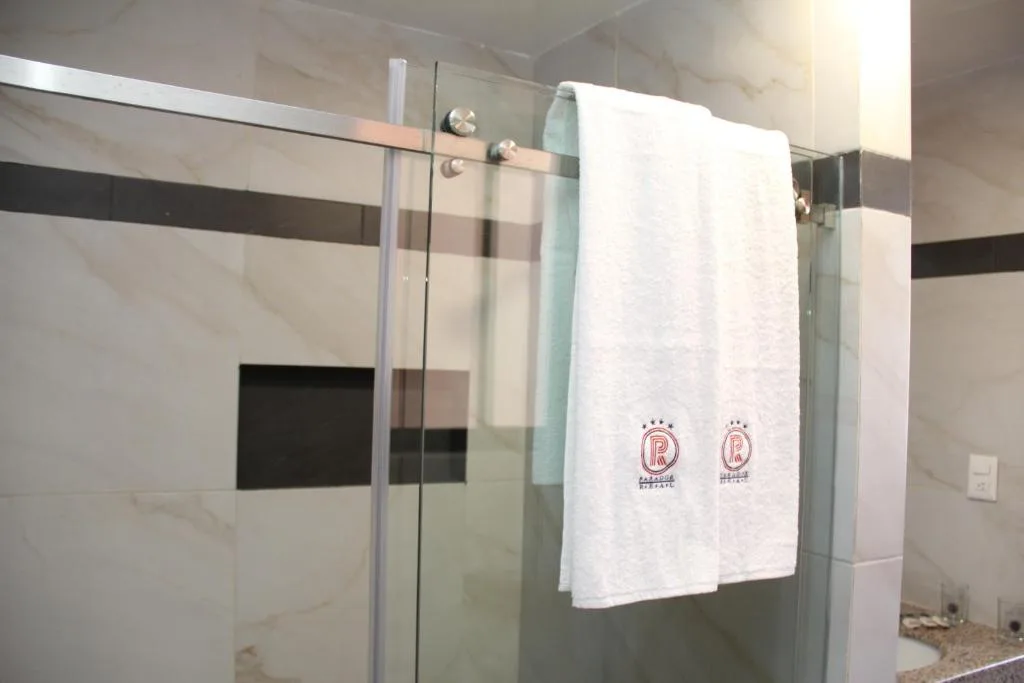 Baño con ducha de cristal y toallas