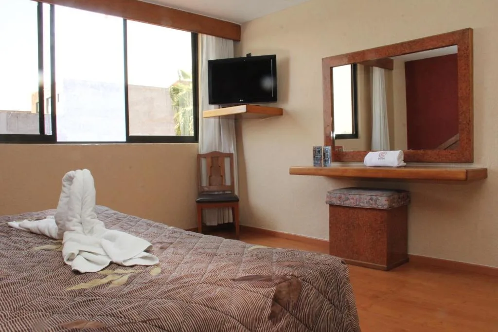 Habitación con cama, televisor y escritorio